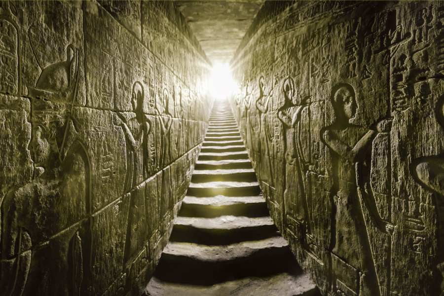 Passage flanked by two glowing walls full of Egyptian hieroglyphs